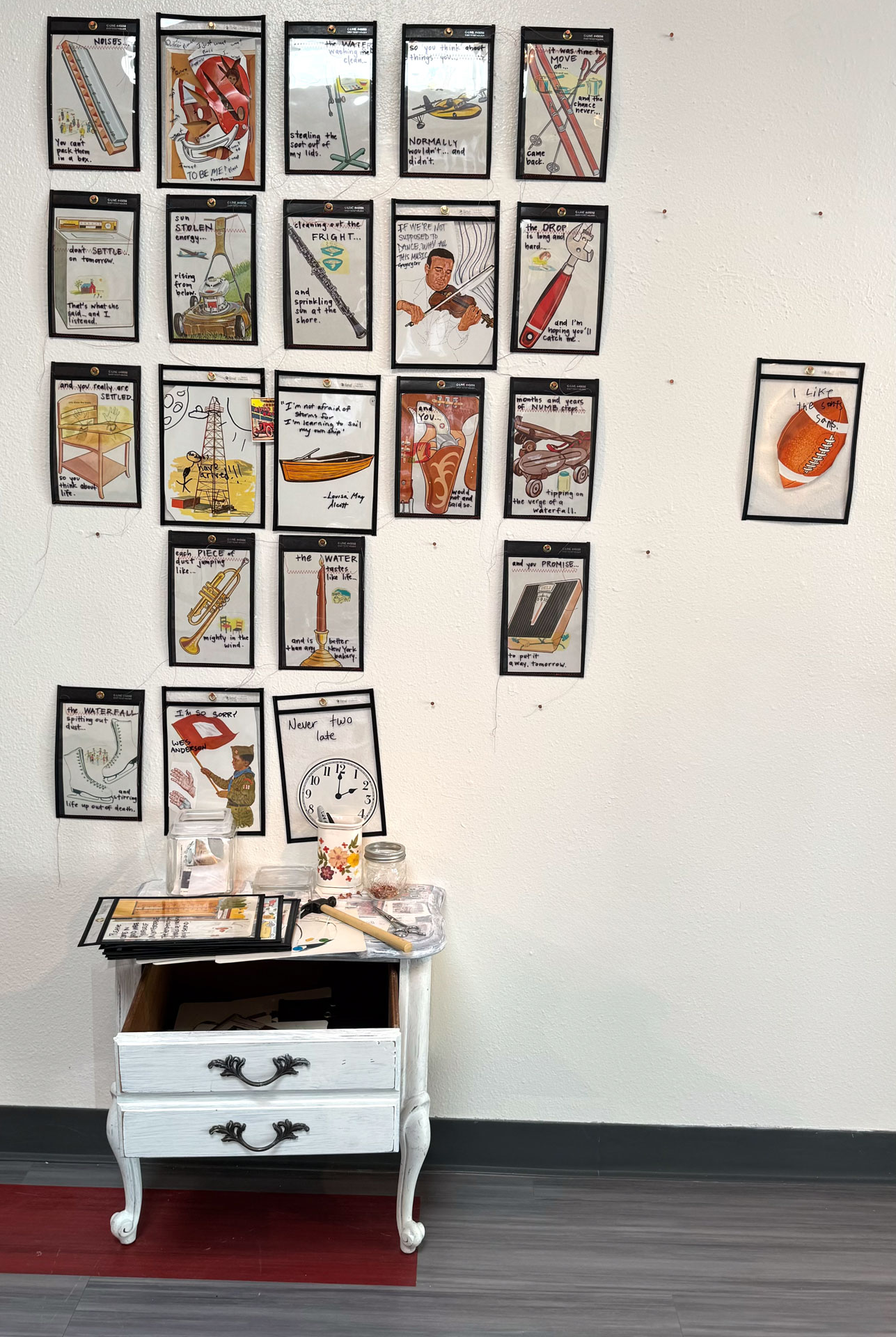 installation with wood table cut in half against wall, job folder, collage materials, audience participation