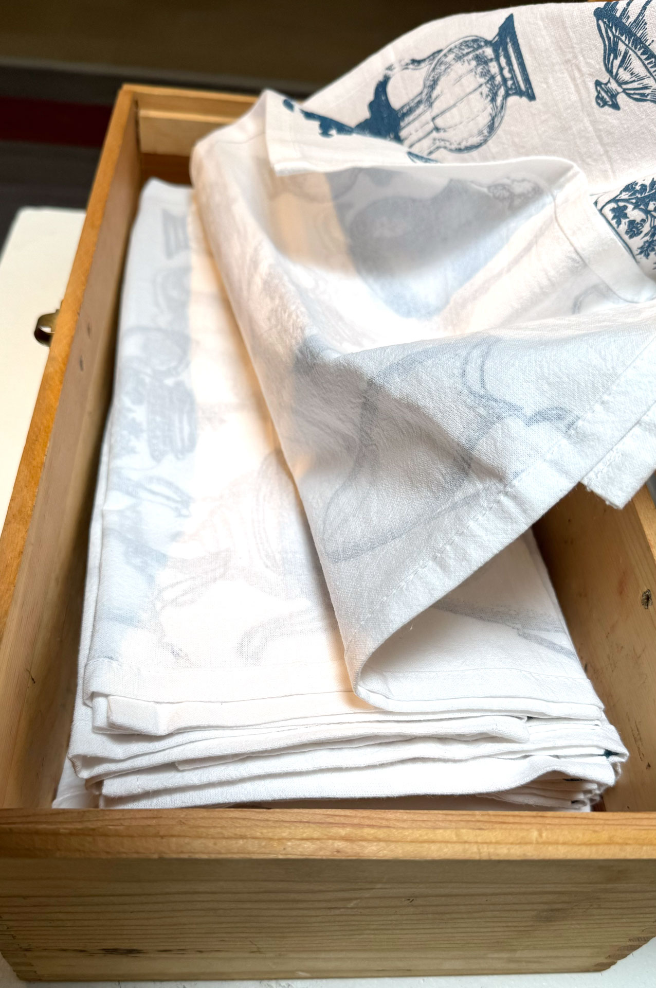 installation with silkscreen napkins attached to ceiling in an arch travelling from a box to a pitcher