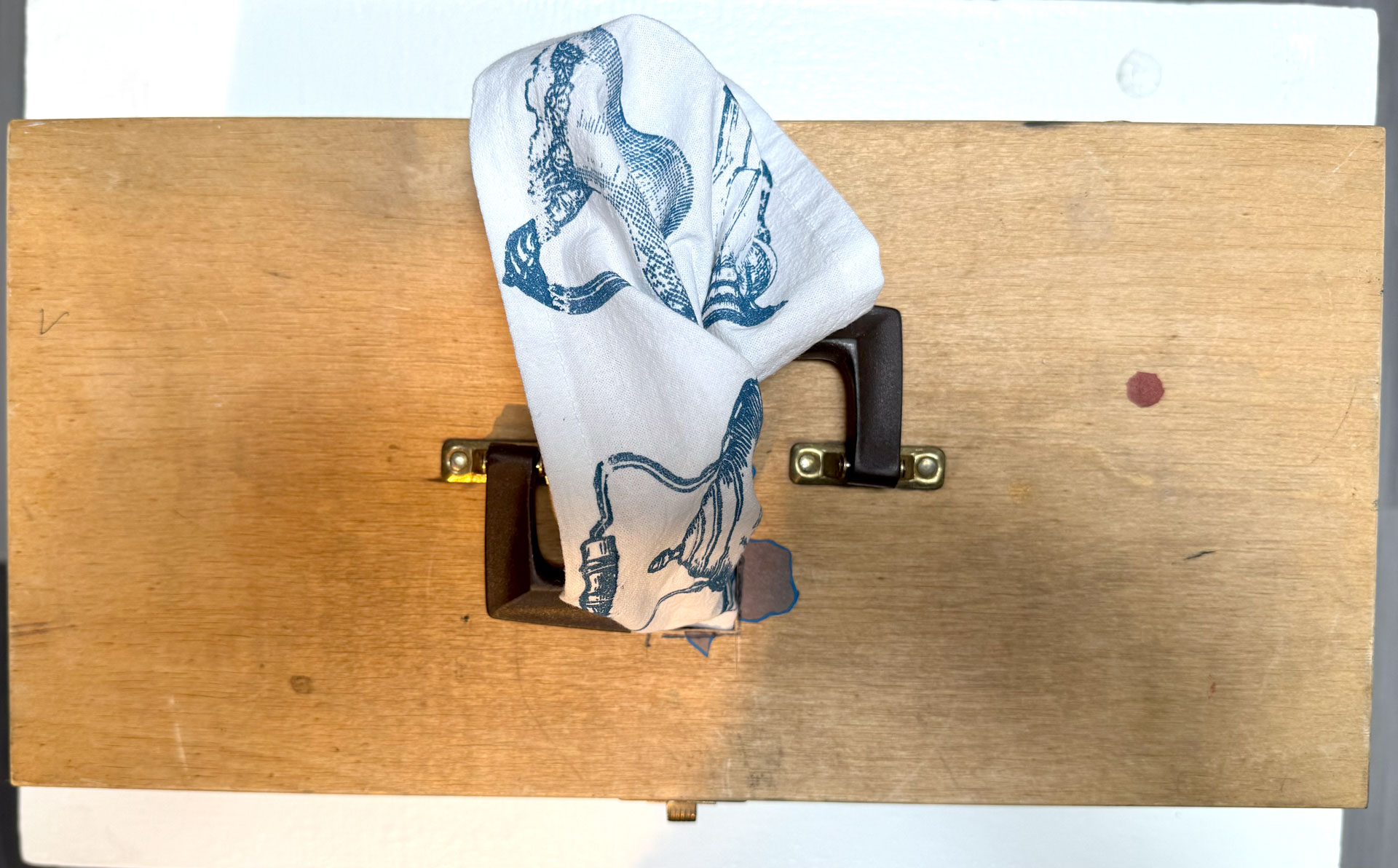 installation with silkscreen napkins attached to ceiling in an arch travelling from a box to a pitcher