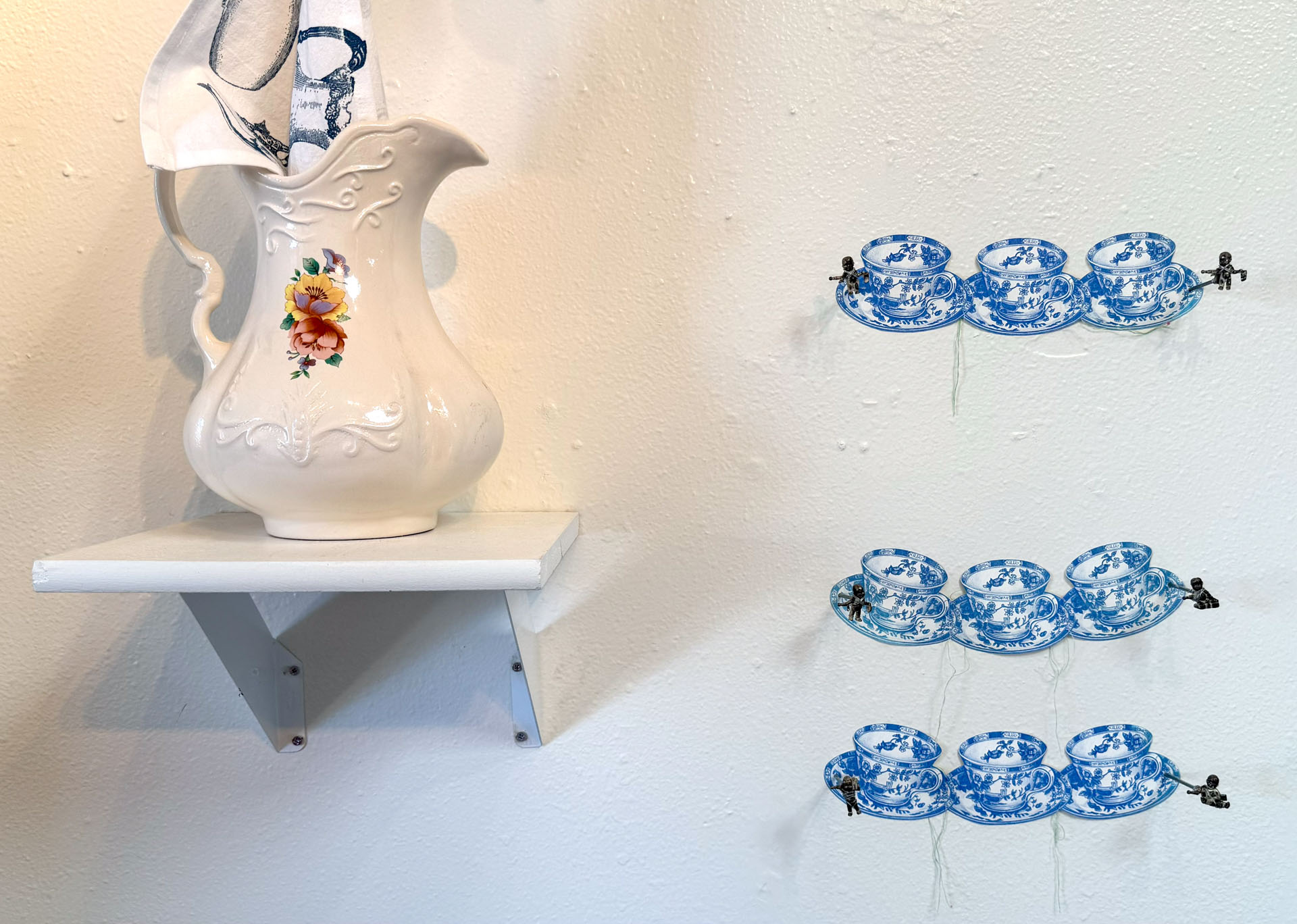 installation with silkscreen napkins attached to ceiling in an arch travelling from a box to a pitcher